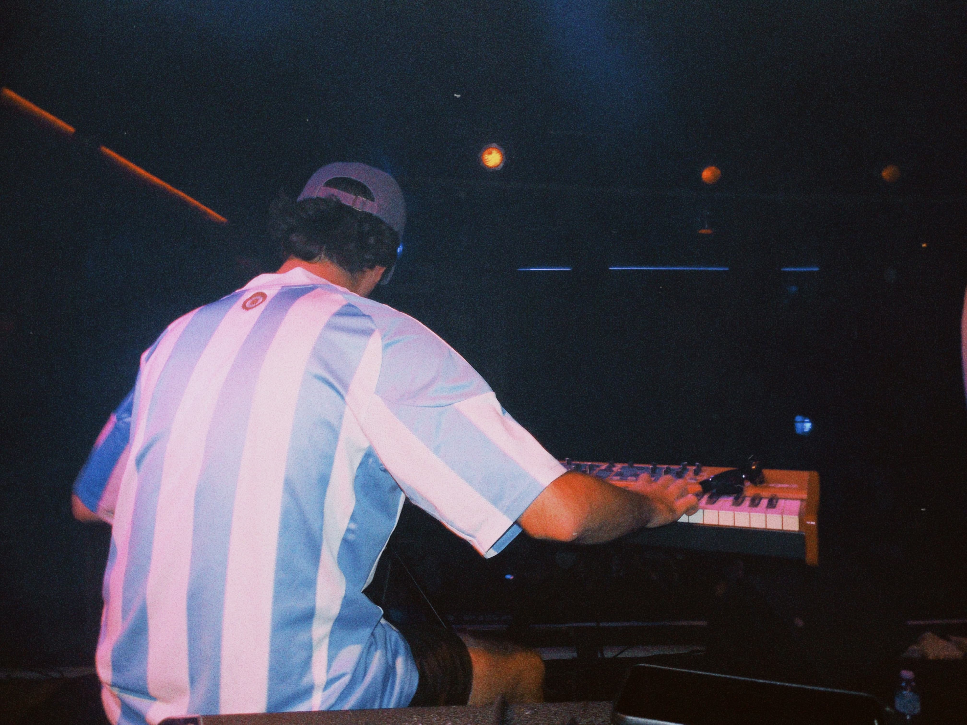 foto de espaldas al pianista con la remera de argentina arriba de el escenario