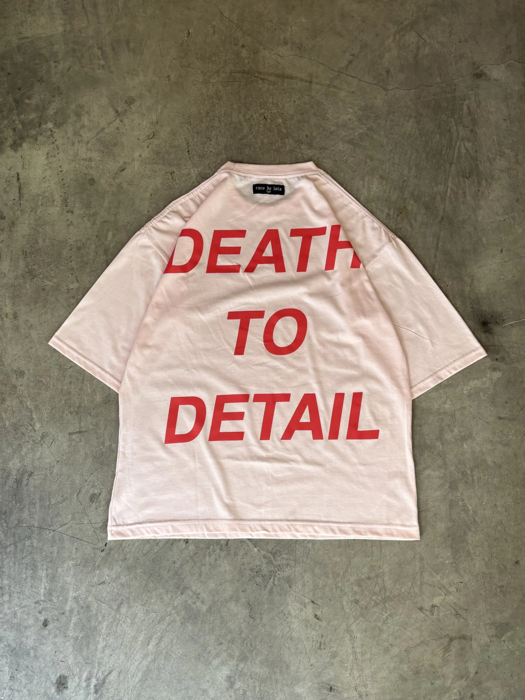 remera color rosa casi blanco que dice death to detail